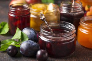 photo of fruit puree with fresh fruit in marmalade and jelly jars with crystal serving spoon