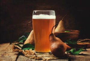 photo of beer in glass with fruit and foliage